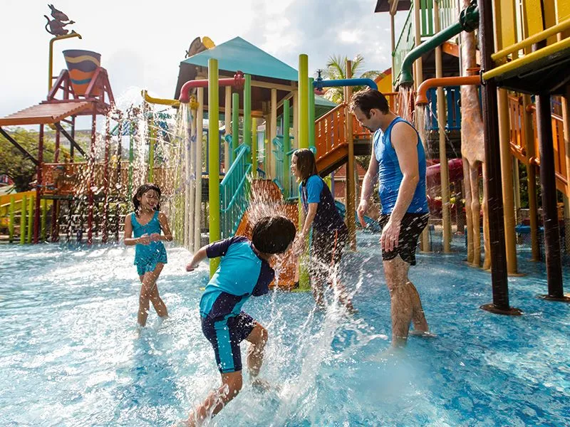 kids splashing water at parents at a water park