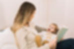 little girl having a fun time reading storybook with her mom