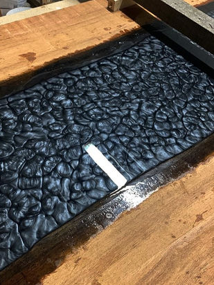 Bijzondere hardhouten tafel met antraciet grijze tinten epoxy. de epoxy hebben wij zijn werk laten doen en het patroon is de uitharding van de epoxy zelf.