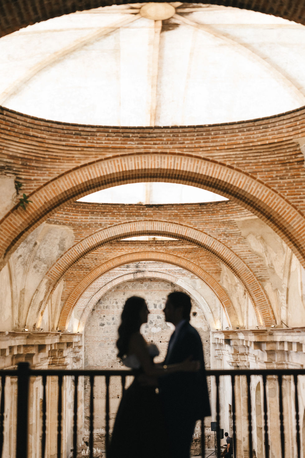 Bride and groom's silhouette against the stunning backdrop of Ruinas de Santa Clara. Historical and elegant wedding venue in Antigua Guatemala. Photographed by Mariel Orellana, top photographer in Antigua Guatemala.