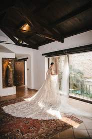Bride getting ready with her long dress in her luxury room at Casa Santo Domingo, iconic wedding venue in Antigua Guatemala.