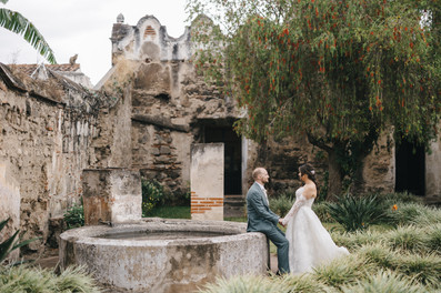 Santa Clara Ruins Gardens, an iconic venue for destination weddings in Guatemala. Bride and groom portrait in the fountain in the garden of the old ruin.