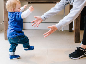 Toddler taking first steps in a pair of lightweight, flexible prewalker shoes, supporting the development of a healthy, natural walking pattern