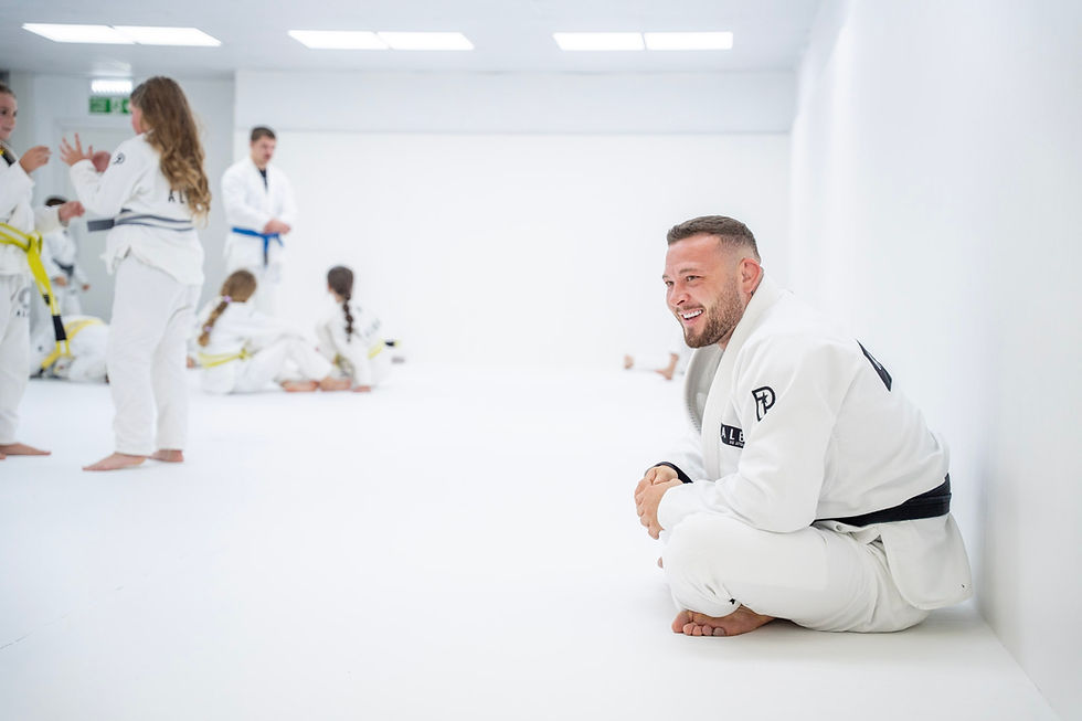 ALBA Jiu Jitsu black belt coach watching students train on the mats