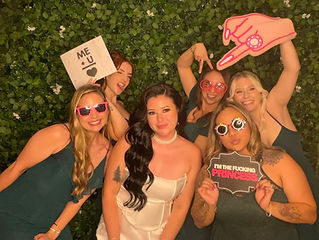 Bride and bridesmaids posing together at a San Antonio wedding photo booth with fun celebration energy.
