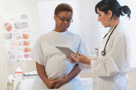 Pregnant Black woman with Doctor