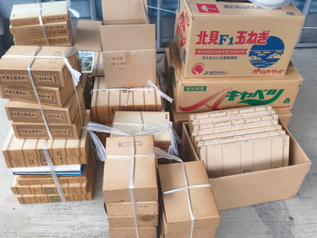 瀬戸市で本の出張買取を行い、本や段ボールが積み上げられている。