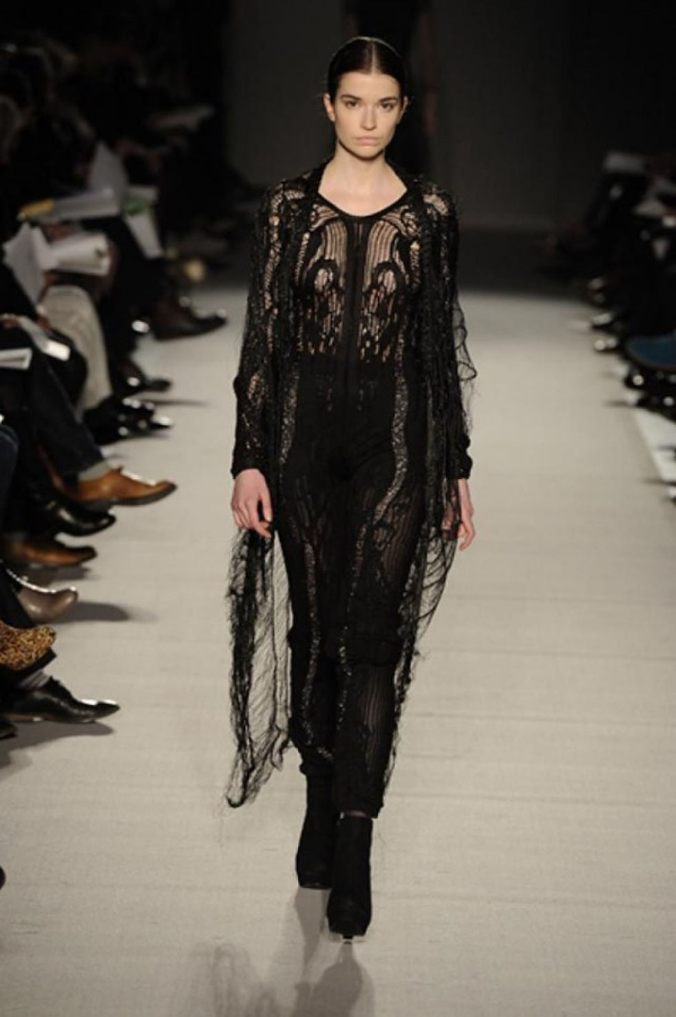 Runway model in KORLEKIE knitted lace jumpsuit and ladder web cardigan