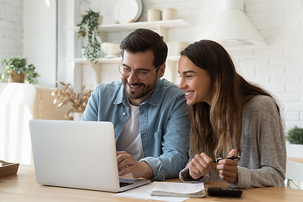 A man and a woman looking at a computer while smiling about what they see.