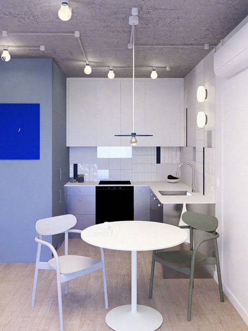 Kuchnia w kolorach bieli i niebieskiego. Fartuch kuchenny wykończony płytkami o różnych kolorach i fakturach.