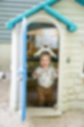 childing playing in plastic toy house