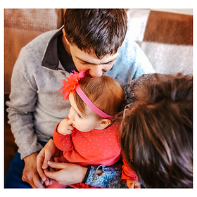 family-photography-dad-kisses-little-girl-with-pink-bow-on-head