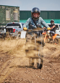 Rider on an electric dirt bike smiling while riding through the TerreMX track at Moto Craft