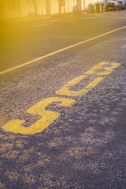 Street photography à Trouville avec filtre jaune, rendu solaire et graphique du mot bus au sol par Chloé Baeyaert.