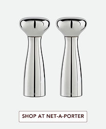 Georg Jensen polished stainless-steel salt and pepper grinders with sculptural curved shape and mirror finish for modern luxury kitchen styling.