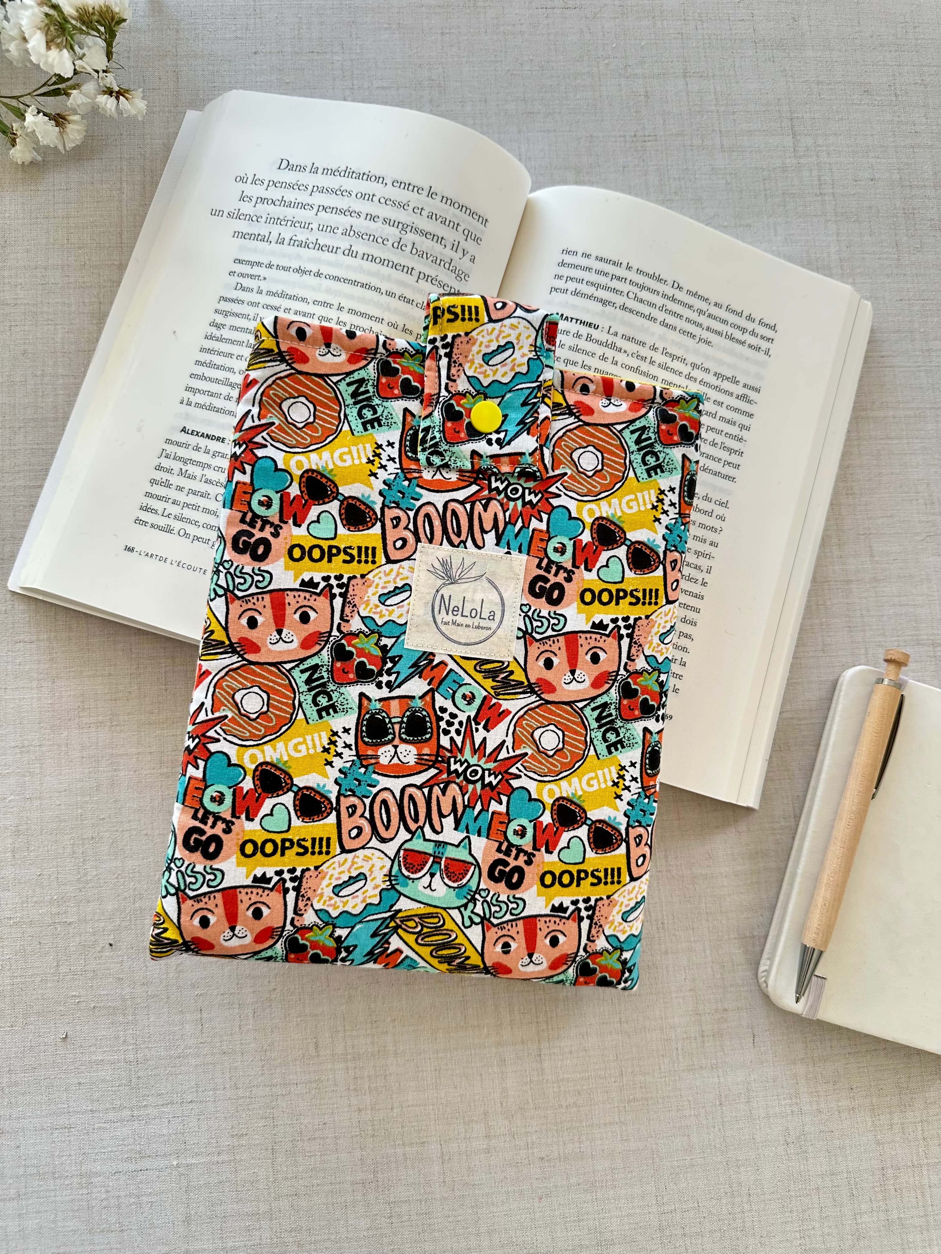 pochette livre de poche avec motif coloré de bande dessiné avec chat, donuts boom - motif enfantin