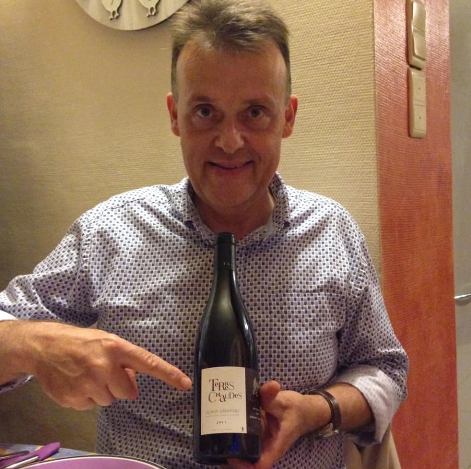 Michel holding a bottle of Terres Chaudes by Thierry Germain