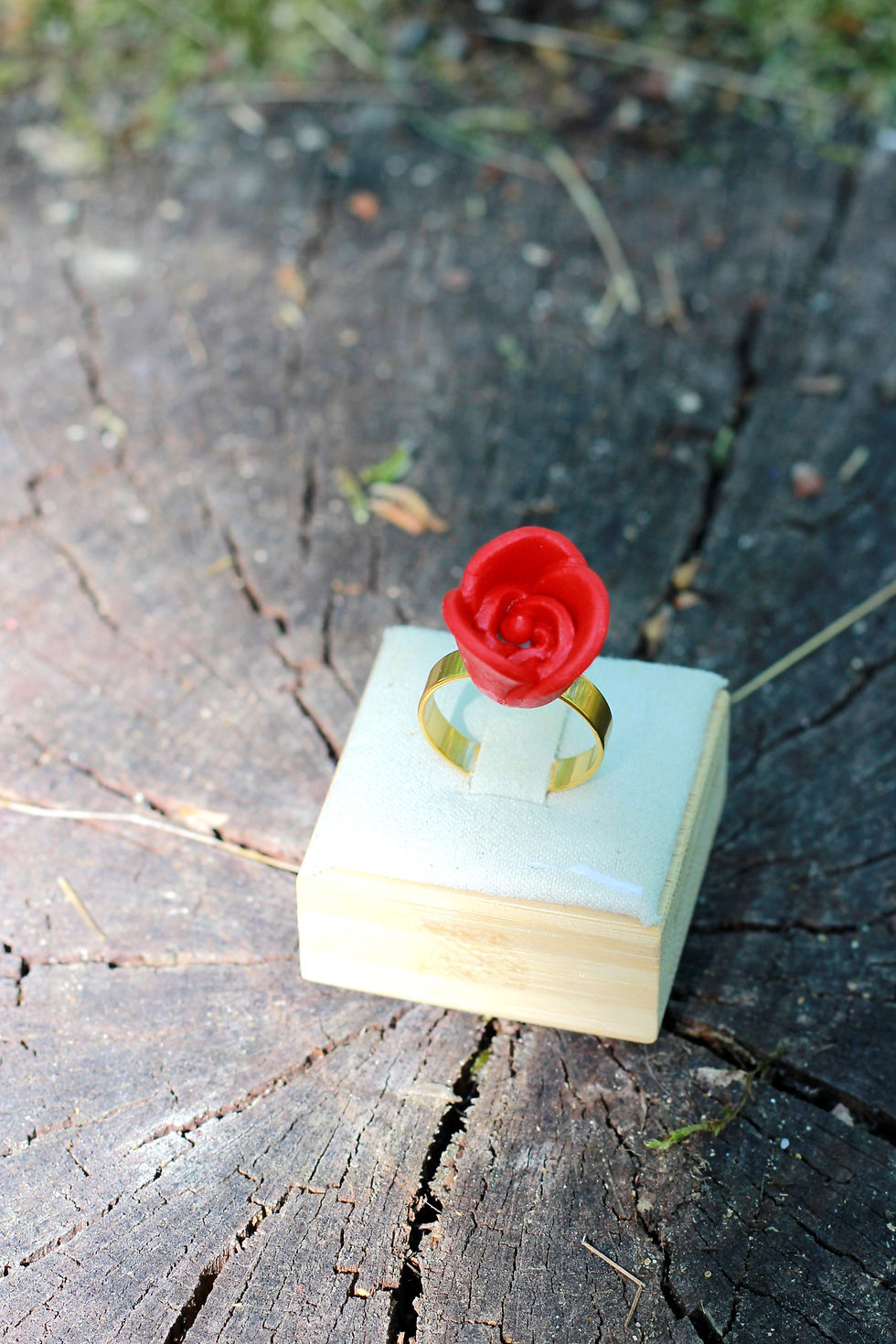 Bague rose rouge en porcelaine montée sur de l'acier inoxydable doré faite à la main en France dans un décor de forêt