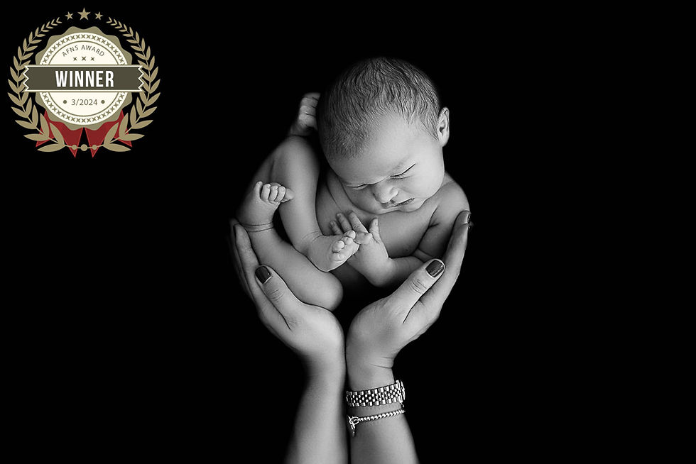 black and white photo of a newborn baby held by mum