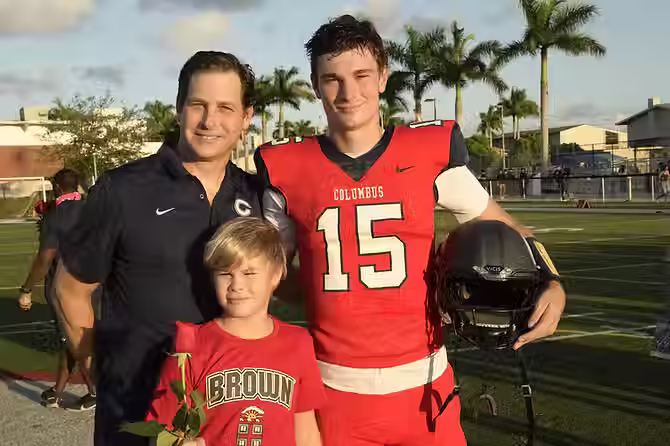 Fernando posing with his little brother and dad during the 2022 Senior Game at Columbus Field. (Source: Adelante Staff)