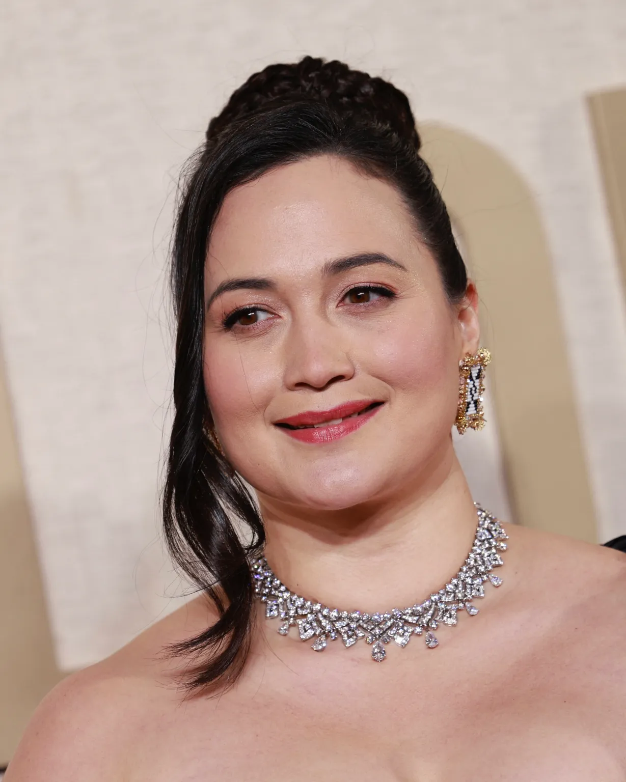 Lily Gladstone In a Bulgari necklace and Antelope Woman Designs earrings.