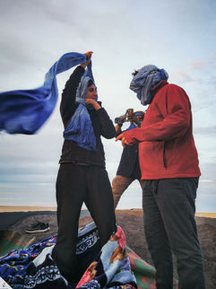 Sofia and Mattia onboard the iron ore railcar adjusting a blue scarf.