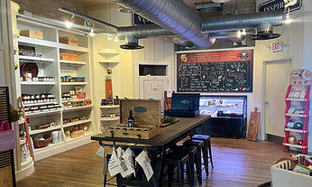 a long view of the store from the back. Featuring the long wooden tasting table