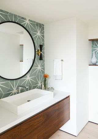 a bathroom with a sink and a round mirror