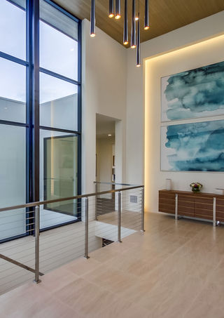 a room with a staircase and two paintings on the wall