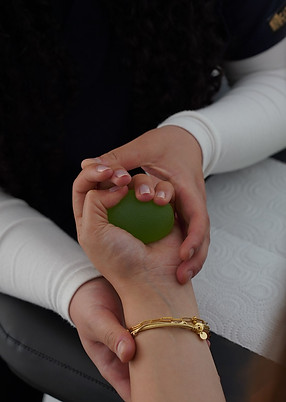 a person squeezing a green ball.jpg