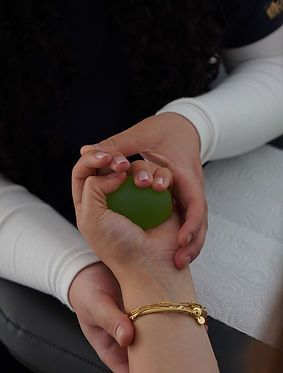 a person squeezing a green ball.jpg