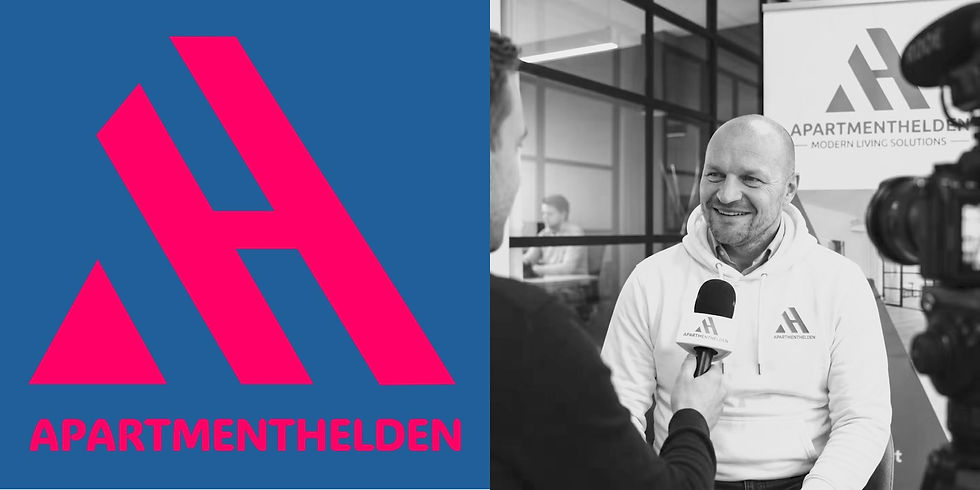 Schwarz-weißes Foto einer Interviewsituation bei APARTMENTHELDEN: Eine Person im APARTMENTHELDEN-Hoodie sitzt in einem Büro und wird mit einem Mikrofon interviewt, im Hintergrund Glaswände und Firmenlogo.