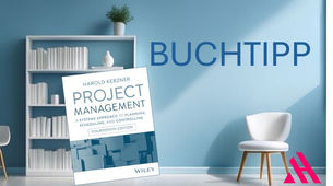BUCHTIPP: Cover des Buches ‚Project Management – A Systems Approach to Planning, Scheduling, and Controlling‘ von Harold Kerzner (14. Auflage) vor einer modernen, hellblauen Wohnzimmerkulisse mit Bücherregal, Stuhl und Pflanzen-Dekoration."