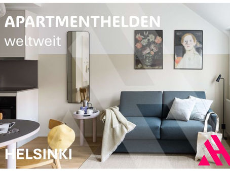 APARTMENTHELDEN weltweit in Helsinki: modernes Serviced Apartment mit grauem Sofa, Wandkunst und Küchenzeile, helles Tageslicht.