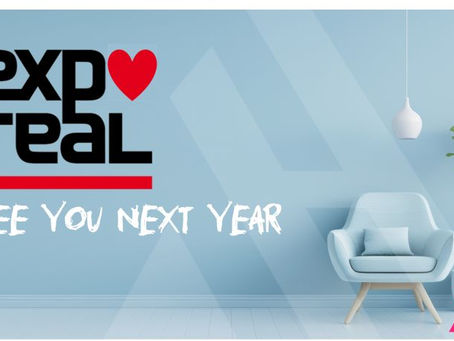 Eine Grafik zur EXPO REAL. An einer hellblauen Wand steht in Schwarz das Logo der EXPO REAL mit einem roten Herzen und darunter der Schriftzug „SEE YOU NEXT YEAR“. Rechts daneben sind ein moderner Sessel, eine Pflanze und das Logo der APARTMENTHELDEN zu sehen.
