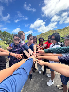 group of young people put hands together for team chant
