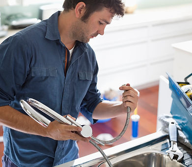 Technician repairs and installs new chrome modern kitchen faucet