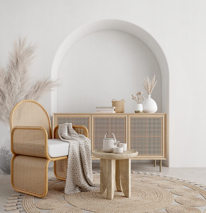 Rattan armchair, wooden cabinet, pampas grass, arched wall