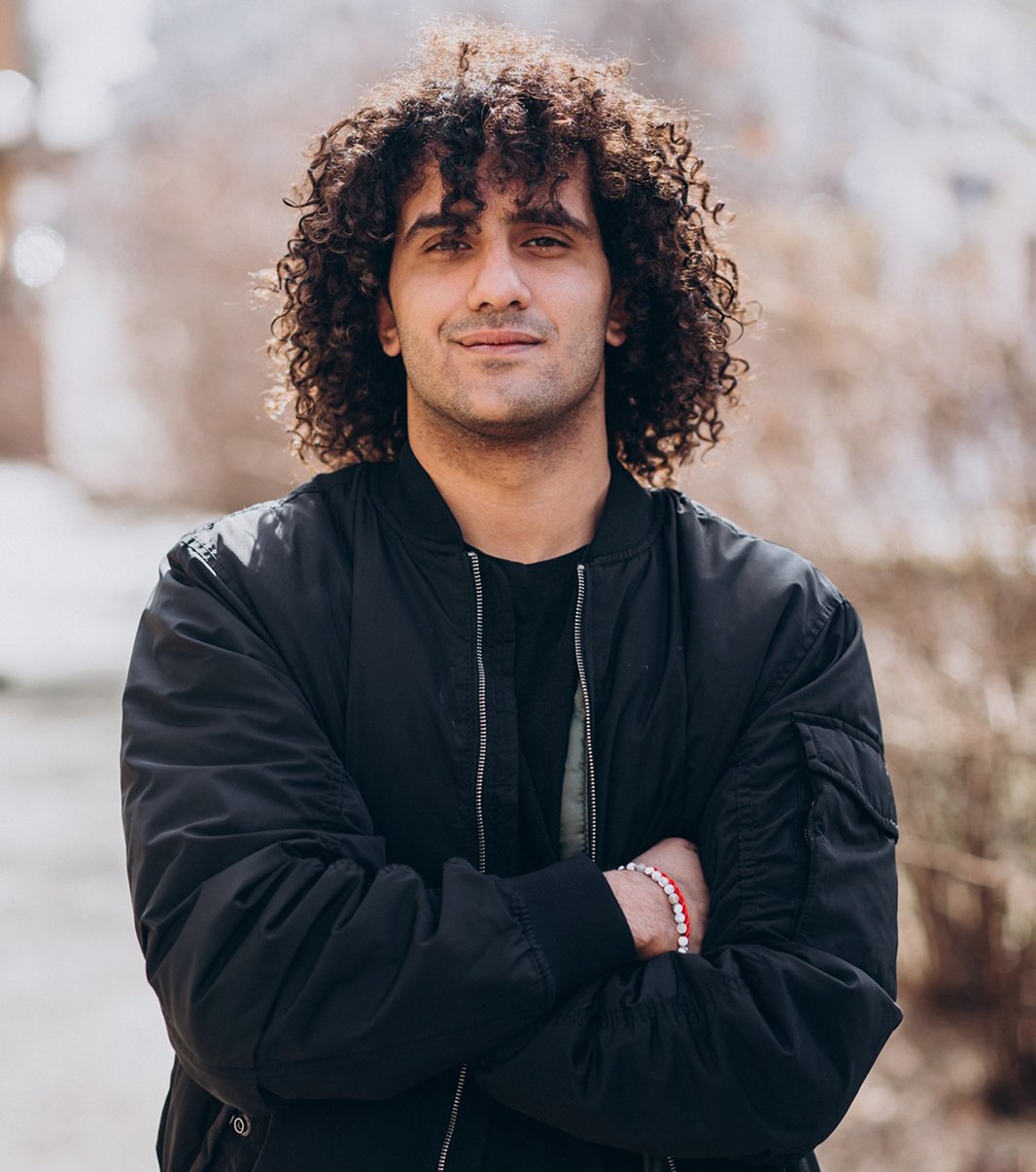 Man with curly hair and crossed arms