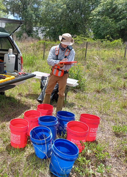 A field technician from Excelsior Environmental Consultants, LLC preparing to install bucket traps for gopher tortoise relocation under a Florida FWC Gopher Tortoise permit in Volusia County.