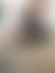 black and white foster kitten, Isabelle, resting on a yoga mat in front of woman sitting cross-legged and petting the kitten