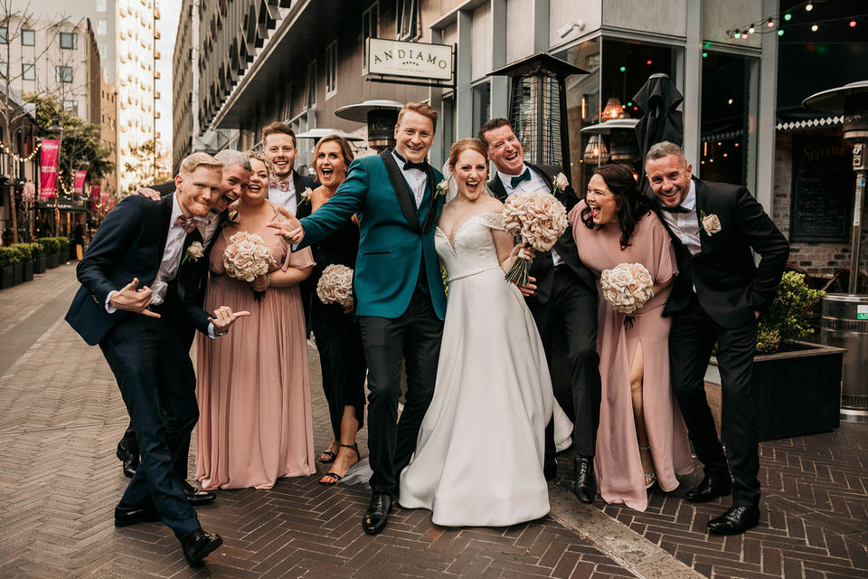 Bridal party laughing and walking together on a Sydney city street.