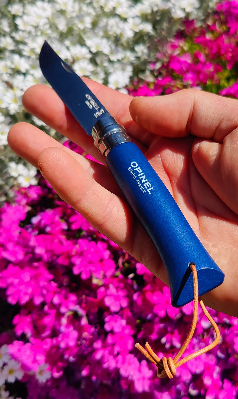 Miniature : Opinel n°08 baroudeur bleu dans la main fond fleurs
