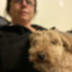 a woman cuddles a poodle