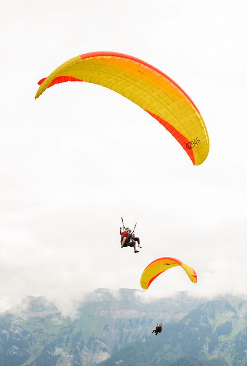 Paragliders flying in Switzerland. Paraglider Tourism Operators.