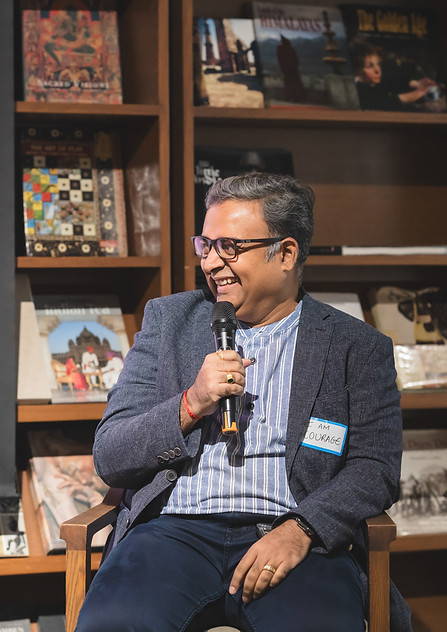 Thumbnail image of a man and woman sitting in a cozy, book-lined room, smiling and posing for a photo.