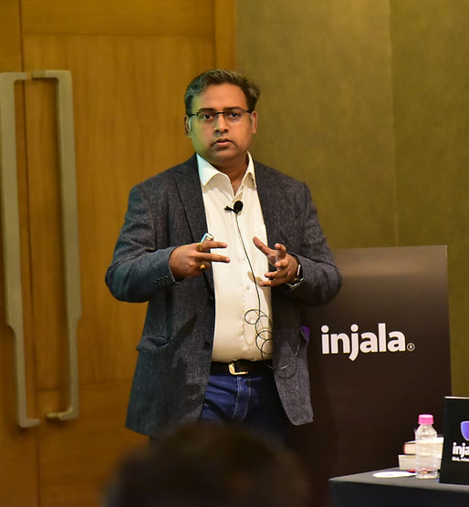 Speaker delivering a session on stage with a mic, presenting to a corporate audience
