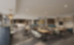 Empty modern dining room with wooden tables, patterned chairs, teal banquettes, and pendant lights under a soft-lit ceiling.