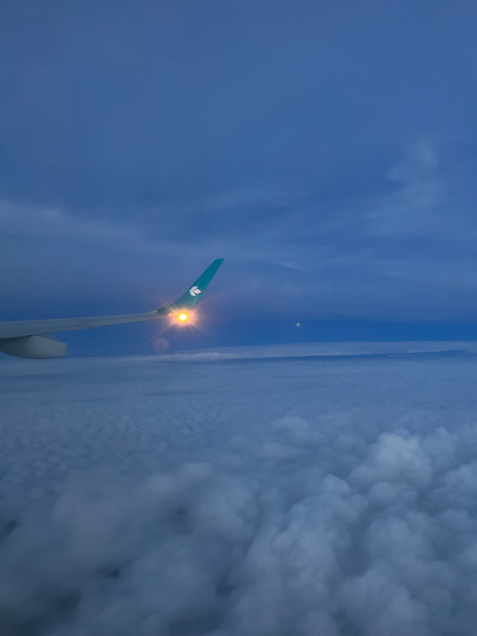 Blick aus einem Flug der Air Dolomiti über die Tragfläche auf das Winglet mit leuchtender Positionsleuchte als Kurierdienst im Flug nach Florenz