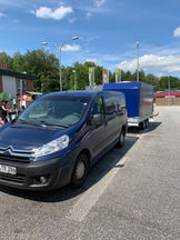 blauer Lieferwagen zieht Anhänger